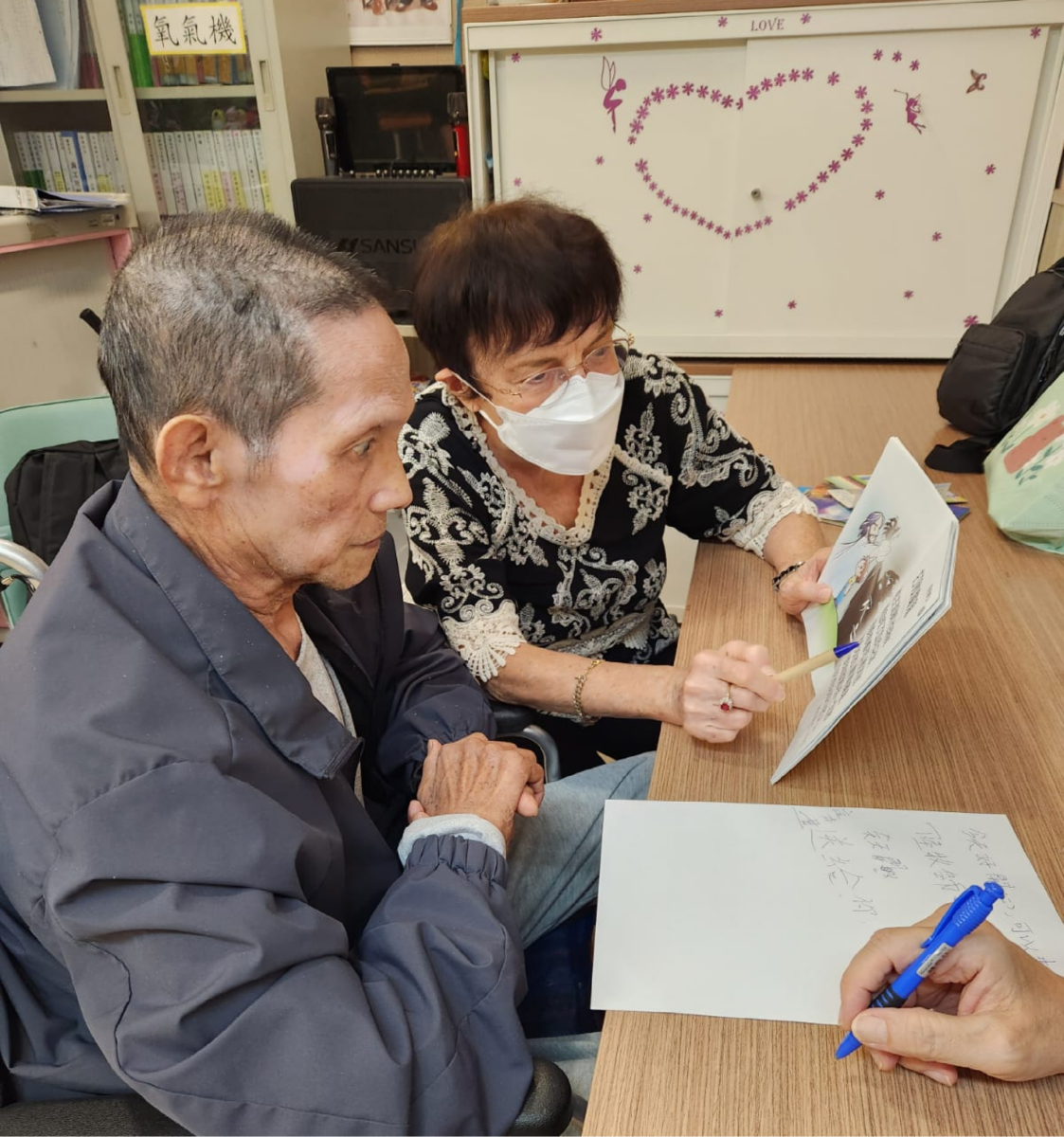 Carol Halter sharing the message of salvation with a deaf Christian residing in a nursing home in Hong Kong.