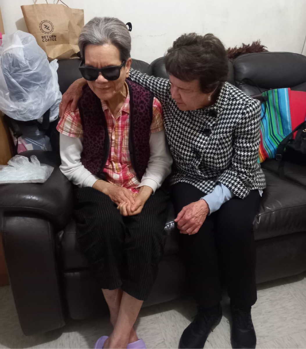 Carol Halter praying for a blind lady in her home.